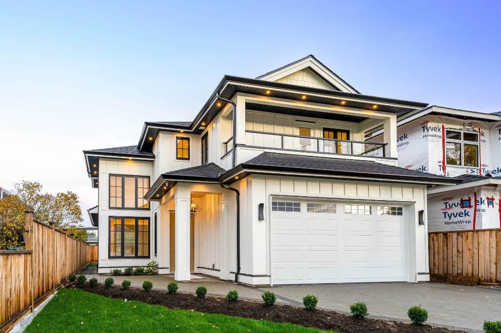 Modern white farmhouse-style custom home exterior with paver driveway