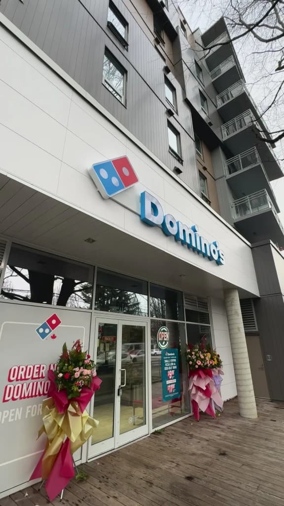 Restaurant storefront exterior at grand opening with branded signage